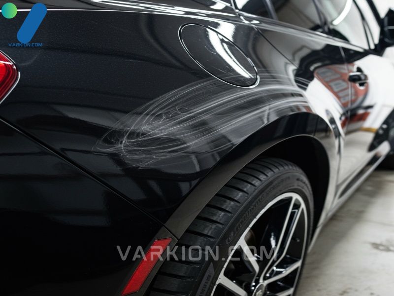 close-up-of-a-black-car-fender-with-visible-holograms-buffer-trails-from-poor-polishing