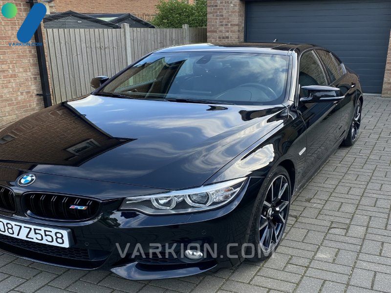 coche-negro-brillante-detallado-en-la-entrada-reflejando-el-cielo-azul