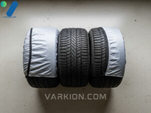 cuatro-neumaticos-de-nieve-apilados-y-cubiertos-en-un-garaje-para-almacenamiento-fuera-de-temporada