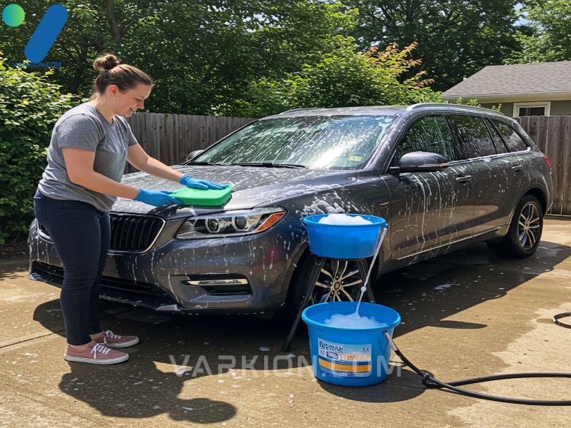 demonstrating-the-two-bucket-car-wash-method-on-a-car-in-a-sunny-driveway