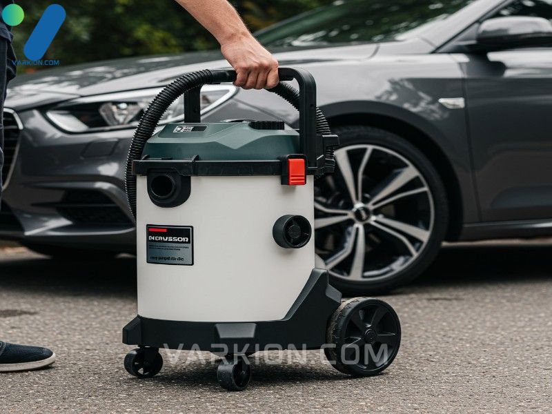 detailer-carrying-a-compact-portable-shop-vac-with-wheels-for-mobile-car-cleaning