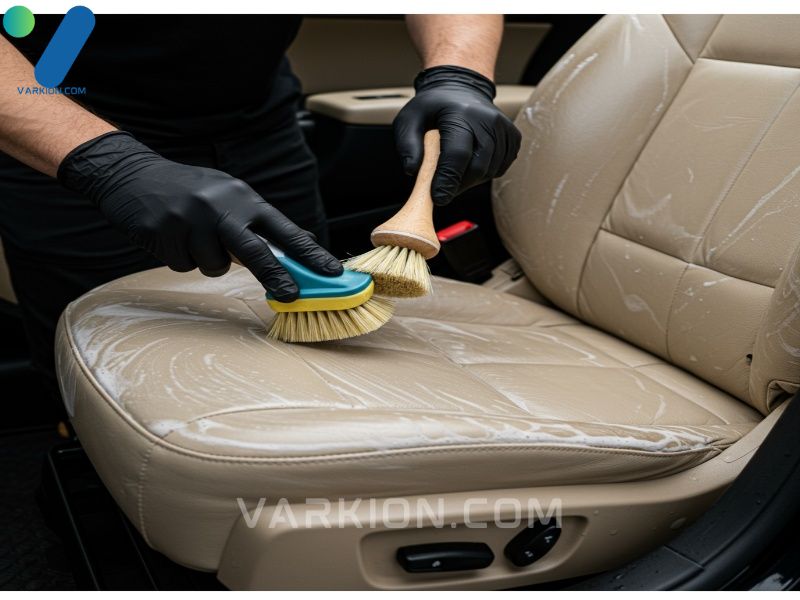 detailer-scrubbing-a-dirty-tan-leather-car-seat-with-a-brush-and-foaming-cleaner