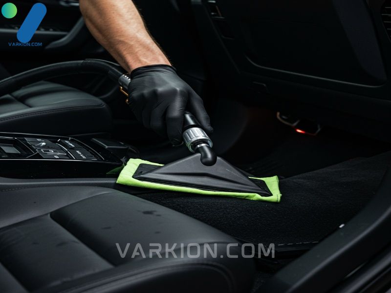 detailer-using-a-narrow-vacuum-crevice-tool-under-the-drivers-seat-and-console-during-interior-cleaning
