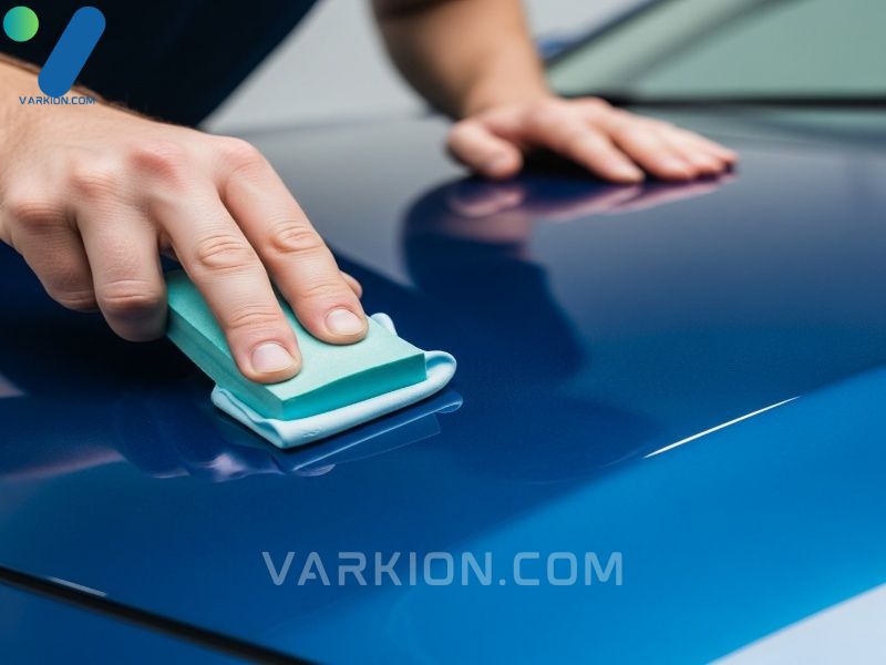 detallista-usando-una-barra-de-arcilla-en-el-capo-de-un-coche-azul