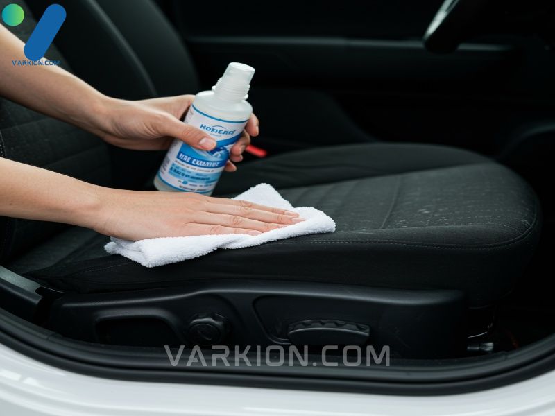 prueba-de-limpiador-de-tapiceria-liquida-en-un-asiento-de-coche-con-un-pano-de-microfibra-blanco