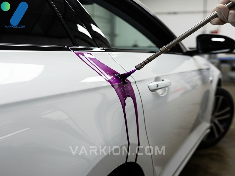 purple-iron-remover-dripping-down-a-white-car-door-panel-during-chemical-decontamination