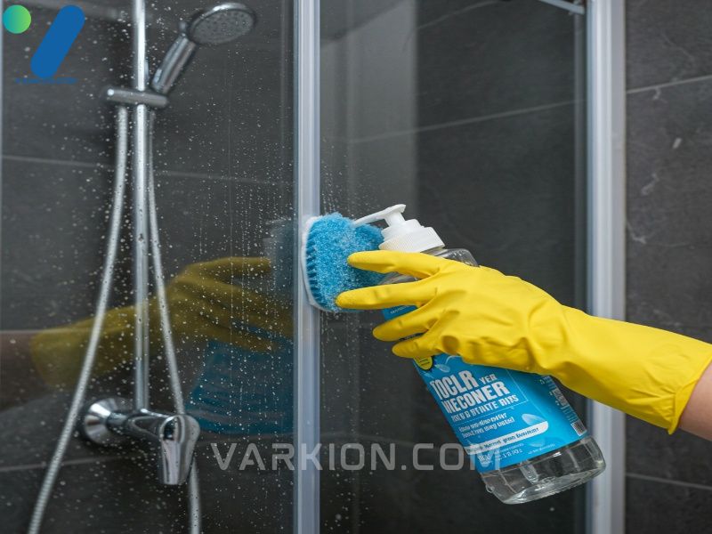 treating-a-shower-door-with-vinegar-and-water-to-dissolve-hard-water-stains